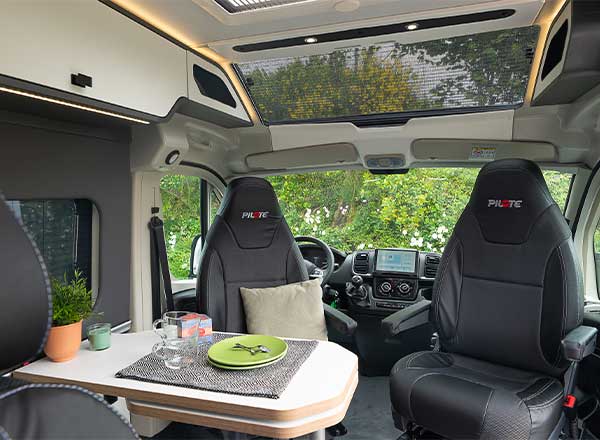 Intérieur d'un fourgon aménagé Pilote avec des sièges noirs