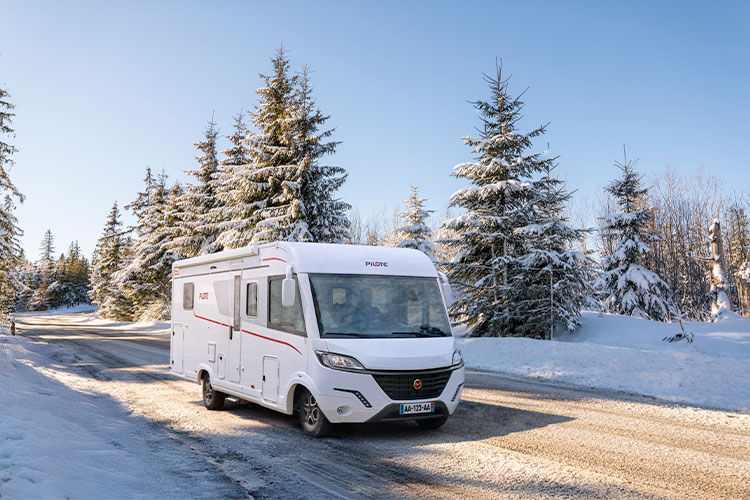 camping-car intégral Pilote roulant sur une route enneigé