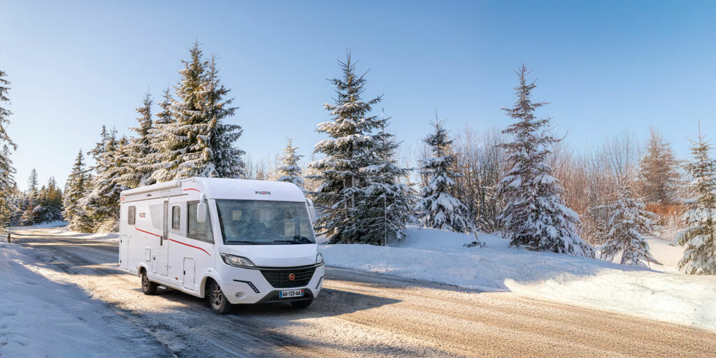 camping-car intégral Pilote roulant sur une route enneigé