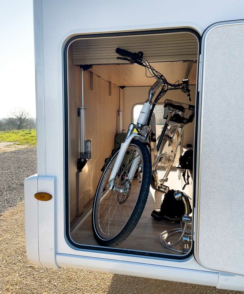 Soute d'un camping-car Pilote avec un vélo à l'intérieur