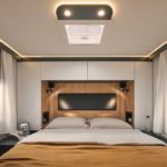 Chambre arrière d'un camping car profilé avec un grand lit et des placards