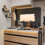 Espace cuisine d'un camping car profilé comprenant un évier en inox et des rangements intégrés.